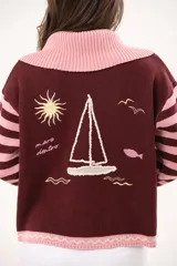 Saco tejido de punto a rayas horizontales en tonos rosado y bordó, con cuello amplio, cierre frontal doble y detalles bordados.