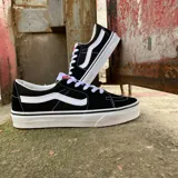 Championes Vans SK8 Low negros con la franja lateral blanca y cordones blancos.