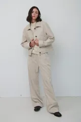 Pantalon de pana color beige, de corte recto y tiro alto, con bolsillos laterales y cintura elástica.