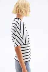 Remera de algodón con rayas horizontales negras sobre fondo blanco. Presenta cuello redondo acanalado negro y mangas cortas amplias.