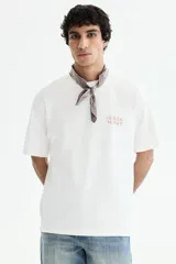 Remera de algodón de corte holgado con cuello redondo y hombros caídos. Presenta un estampado minimalista con el nombre Claude Monet en el pecho.