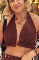 Collar de diseño artesanal con dije metálico en forma de estrella de ocho puntas, combinado con una cadena de eslabones dorados y una tira de cuero sintético marrón.