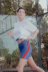 Short biker de lycra azul con franjas laterales rojas y bolsillo para pelotas de tenis.