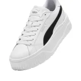 Championes Puma modelo Karmen II L, de diseño urbano con plataforma. Presentan una capellada de cuero blanco con la icónica franja lateral de la marca en color negro y suela de plataforma robusta con textura estriada.