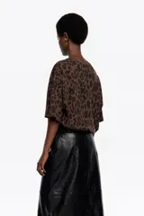 Camiseta de manga corta, corte oversize y escote redondo. Presenta un estampado de leopardo en tonos marrones y negros.