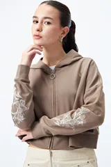 Canguro cropped negro con cierre frontal y estampa abstracta en contraste en las mangas.