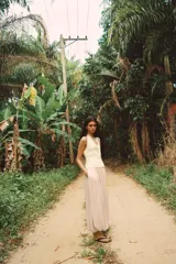 Chaleco color crema de punto, con escote en pico y sin mangas. Cierre cruzado frontal con lazada lateral.