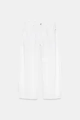 Jeans blancos de tiro medio con cinco bolsillos, detalle de costuras torcidas y cierre frontal con cremallera y botón metálico.