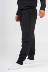 Pantalón de jogging unisex de felpa, color verde oscuro, con cintura elástica con cordón de ajuste y puños elásticos en los tobillos.