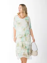 Vestido dos en uno confeccionado en seda italiana, con capa superior de calce amplio y falda con volados que aportan movimiento. Incluye forro en algodón elastizado que se adapta cómodamente a distintos talles. Un diseño versátil y liviano, ideal para eventos, días de calor o looks más relajados según cómo lo combines.