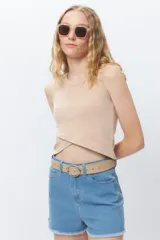 Musculosa corta negra sin mangas, de corte asimétrico frontal y ceñida al cuerpo.