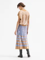 Pollera larga de tejido de punto con diseño de tablas, decorada con lentejuelas bordadas en un patrón de rayas verticales y bloques horizontales en tonos azul y tostado.