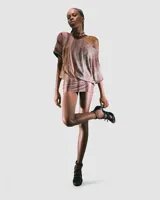 Minivestido con estampado abstracto en tonos marrones y rosados, con un hombro descubierto y corte ajustado.