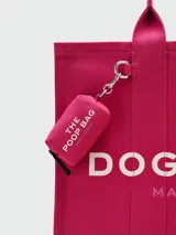 Bolso tote color fucsia, modelo The Doggy Bag, con texto estampado en blanco que dice "THE DOGGY BAG MARC JACOBS". Presenta un diseño acolchado vertical y asas de mano.