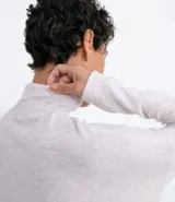 Camisón largo de tejido de punto color gris claro, con cuello alto y mangas largas. Tiene aberturas laterales.