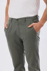 Pantalón de lino color beige, de corte recto y cintura elastizada con presillas para cinturón y bolsillos laterales.