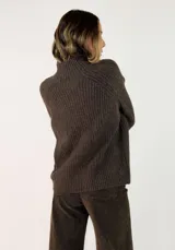 Sweater de tejido de punto acanalado en color marrón oscuro, con cuello alto y mangas largas con corte raglán.