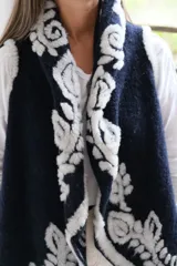 Chaleco abierto de lana en color azul marino, con diseño de bordes en contraste con estampado floral en tonos claros. Presenta un corte holgado y sin mangas.
