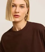 Remera básica de corte relajado, confeccionada en tejido de punto de algodón. Presenta cuello redondo y mangas cortas, con un diseño liso y holgado que ofrece comodidad y versatilidad.