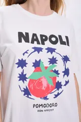 Remera blanca de manga corta con estampa de un tomate rodeado de estrellas azules y la inscripción "Napoli Pomodoro Bon Appetit".
