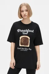 Remera blanca de algodón con cuello redondo, mangas cortas y calce holgado. Cuenta con un estampado frontal de estilo gráfico que dice "Negroni" junto con la ilustración de un trago y rodajas de naranja.
