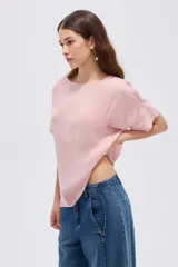 Blusa rosada de poliéster, con diseño holgado, cuello a la base y mangas cortas.