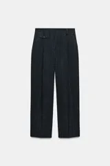 Pantalón de tiro medio con diseño de pernera recta, confeccionado con pinzas frontales y detalle de tapeta. Cuenta con bolsillos laterales y cierre frontal con cremallera, botón y ganchos.