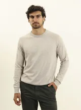 Sweater de punto color naranja, con cuello redondo y mangas raglán.