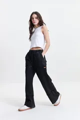 Pantalón de felpa negro con cintura elastizada ajustable, bolsillos laterales y corte acampanado.