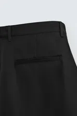 Pantalón de corte relaxed fit con pinzas delanteras, confeccionado en una mezcla de algodón, lino y lyocell. Presenta bolsillos laterales, bolsillos traseros de vivo y cierre frontal con cremallera y botón.