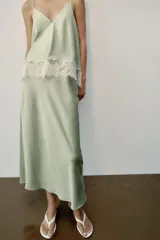 Vestido midi de satén color verde menta con escote en V, tirantes finos y detalle de encaje blanco en el pecho.