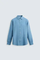 Camisa de corte regular fit confeccionada en tejido de lino, con cuello solapa, manga larga con puños abotonados y cierre frontal de botones.