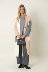 Cartera de mano color verde esmeralda, con herrajes dorados y asa corta.