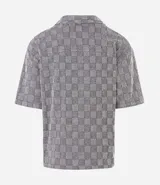 Camisa de manga corta Marfinno con corte boxy, cuello bowling y cierre frontal abotonado. Confeccionada en tejido texturizado con diseño geométrico de cuadros.