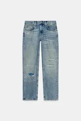 Jeans de tiro medio con corte recto y largo completo. Presentan un diseño de cinco bolsillos, cierre frontal con cremallera y botón, y un acabado con efecto lavado. Incluyen detalles de roturas y parches decorativos en la parte delantera.