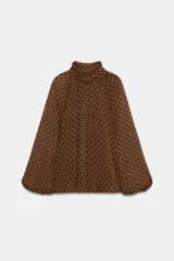Blusa de cuello subido con diseño de lunares, manga larga abullonada con puños elásticos y forro interior.