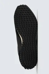 Zapatilla de estilo retro con cordones, confeccionada en una combinación de materiales textiles y piezas de cuero con acabado serraje. Presenta una suela dentada en contraste de color.