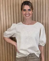 Blusa de puro lino color beige, con escote redondo y mangas cortas abullonadas con puños elastizados.