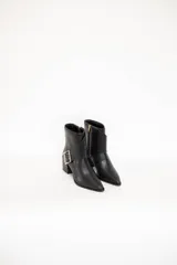 Bota corta de cuero negro con textura tipo reptil, punta ligeramente afilada y tacón medio cuadrado. Presenta una correa decorativa con hebilla metálica lateral.