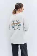 Sweater de punto color bordó, con cuello redondo, manga larga y diseño holgado. Presenta detalles bordados en hilo dorado en la zona del hombro y en el puño.