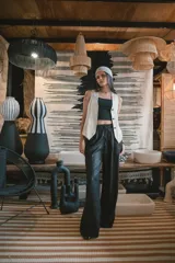 Pantalón de corte amplio y tiro alto, confeccionado en tela negra con acabado brillante y sutil efecto glitter. Presenta cintura elástica con cordón ajustable y caída fluida.