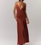 Vestido largo color verde oliva, con escote en V profundo, tirantes finos y fruncido en el corpiño. La falda es suelta y fluida.