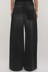 Jeans de tiro medio confeccionado en 100% algodón sin elasticidad, con diseño de pierna amplia y fluida, bolsillos plaqué delanteros y efecto de lavado oscuro con quiebres localizados.