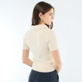 Sweater de punto con textura efecto pelo, color beige, de manga corta y cuello tipo polo con escote en V.