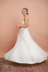 Vestido largo de microtul blanco con brillo y apliques de flores, con breteles finos y falda con vuelo. Ideal para quinceañeras.