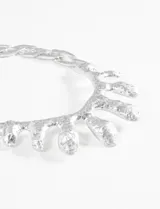 Collar plateado con cadena de eslabones gruesos y dije central con forma orgánica irregular.