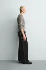 Pantalón cargo de corte relajado confeccionado en tejido de algodón con elasticidad. Presenta bolsillos laterales tipo cargo con solapa en las perneras, bolsillos frontales y bolsillos traseros de doble vivo. Cierre frontal con cremallera y botón.