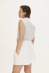 Short de tiro alto color blanco con bolsillos frontales y cierre con broches sastreros.
