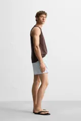 Short de baño celeste con estampado geométrico paisley, cintura elástica con cordón ajustable, bolsillos laterales y bolsillo trasero.
