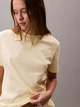 Remera Calvin Klein Jeans de manga corta y cuello redondo, color amarillo claro, con el logo de la marca estampado en el pecho en tono blanco.